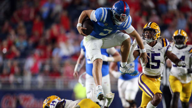 Sep 30, 2023; Oxford, Mississippi, USA; Mississippi Rebels quaterback Jaxson Dart (2) leaps over LSU Tigers defensive back Andre' Sam (14) during the second half at Vaught-Hemingway Stadium. Mandatory Credit: Petre Thomas-USA TODAY Sports